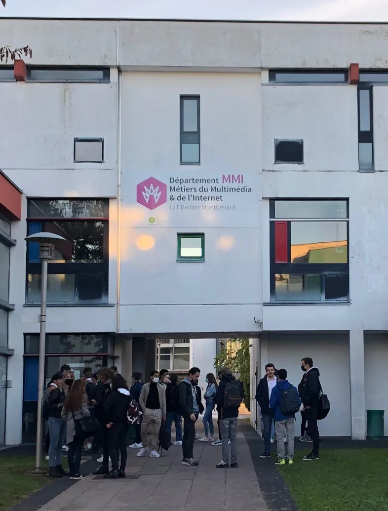 A large white building with students in front